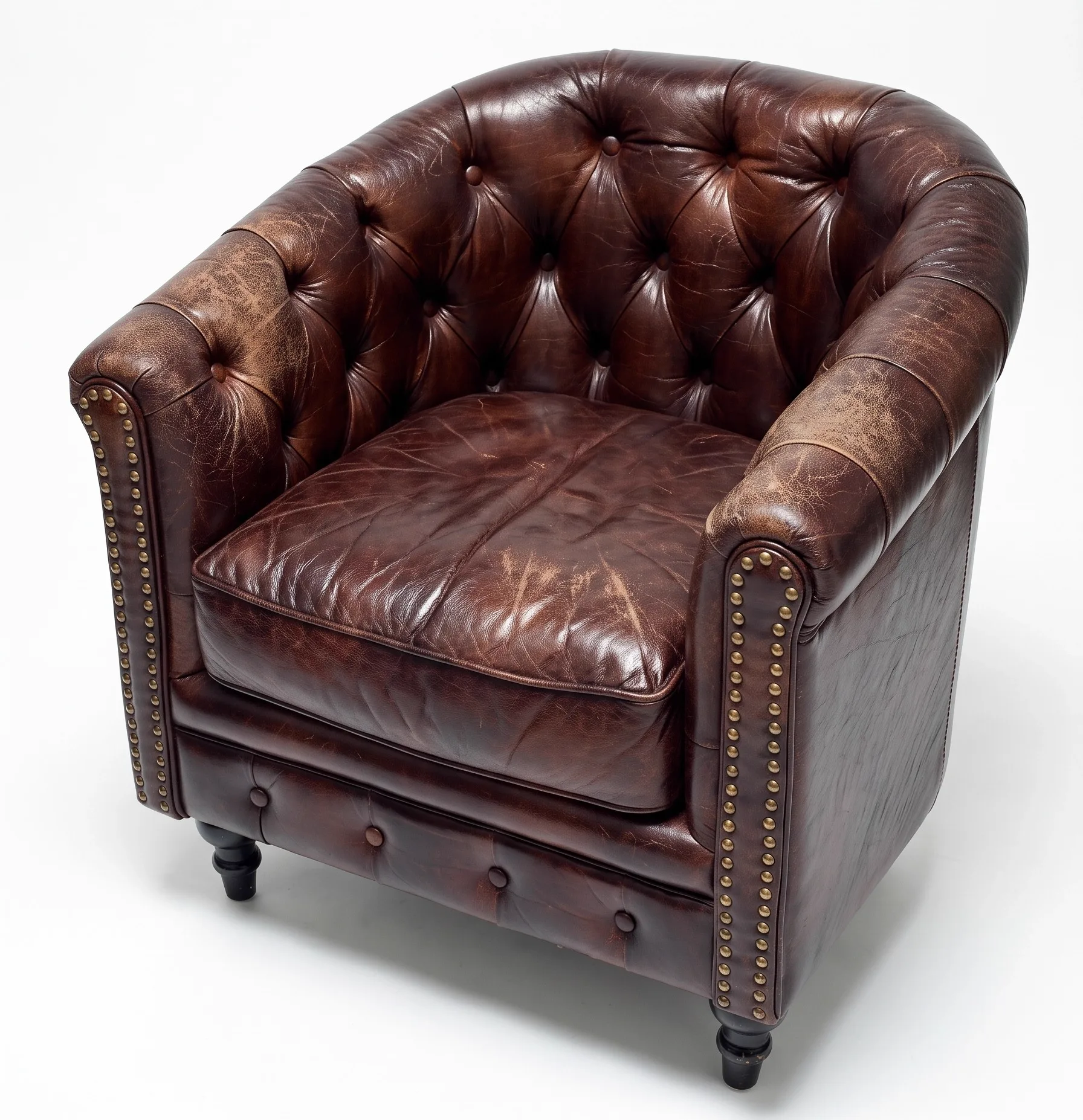 Faded, cracked dark-brown buttoned leather tub club chair before restoration